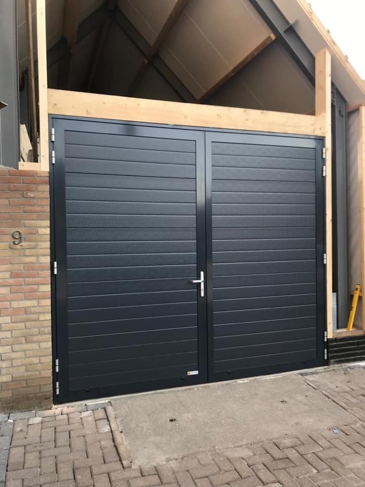 Openslaande garagedeur voor schuur aan woning. Maatwerk door Elzinga Bedrijfsdeuren Techniek